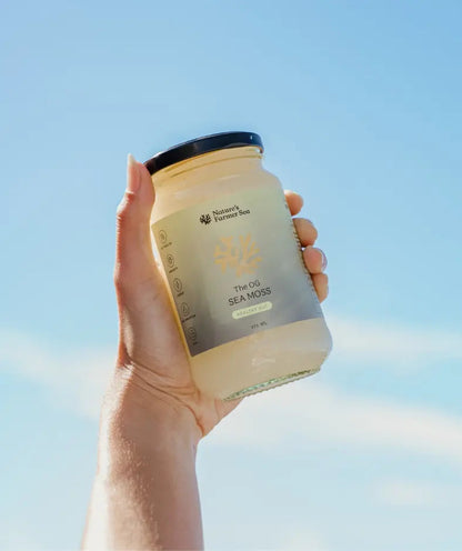 Nature's Farmer Sea The OG Sea Moss Gel 375ml jar held against a blue sky